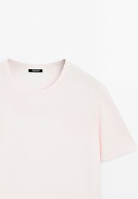 T-shirt rosa chiaro a maniche corte realizzato in morbido cotone, con scollatura rotonda e un'etichetta vicino al colletto con informazioni sul marchio.