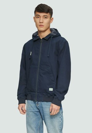 Marineblaue Zip-Hoodie mit Kordelzugkapuze, Kängurutasche vorne, gerippten Bündchen und Saum, gefertigt aus einem Baumwollmischgewebe.