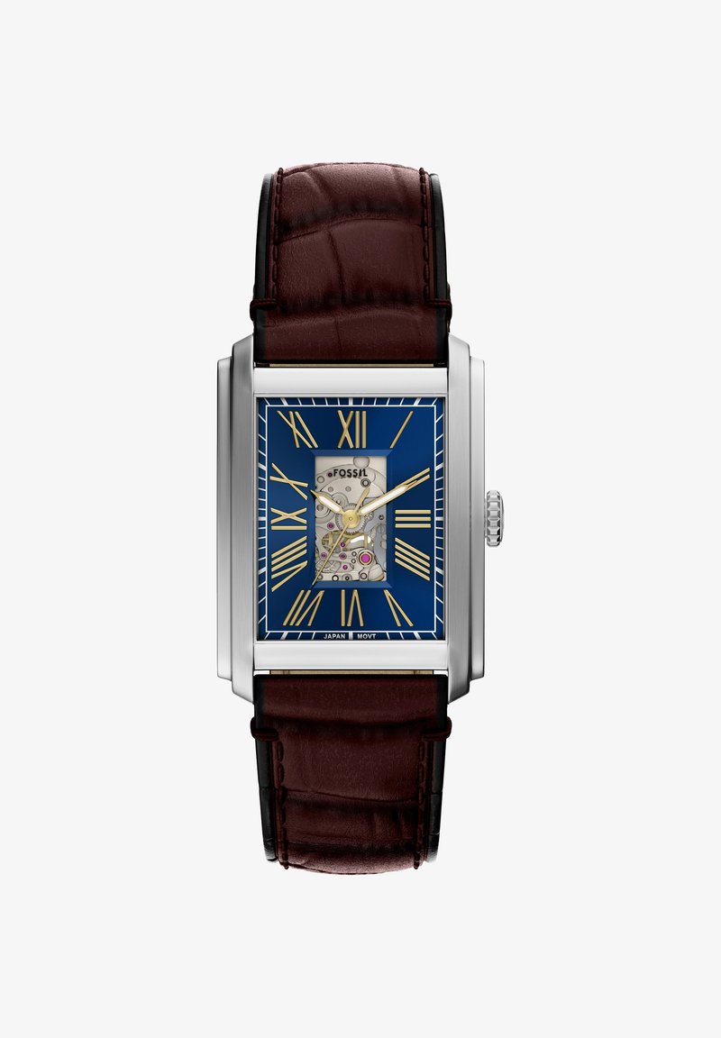 Montre rectangulaire argentée avec cadran bleu, chiffres romains dorés, engrenages visibles au centre, et bracelet en cuir marron foncé à motif texturé.