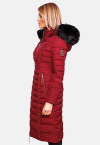 Cappotto puffer rosso con chiusura lampo frontale, tasche laterali e cappuccio in pelliccia sintetica. Presenta un design aderente e una texture trapuntata per l'isolamento.
