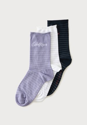 Trois paires de chaussettes fines rayées en violet, blanc et noir, empilées en légère superposition sur un fond clair.