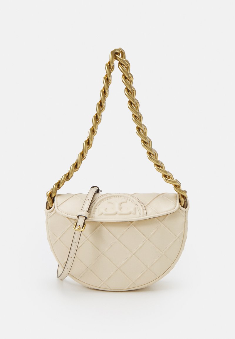 Sac à main en crème matelassé avec une bandoulière en chaîne dorée. Il présente une forme arrondie, une fermeture à boucle latérale et un détail de logo en relief à l'avant.