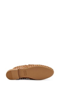 Scarpa slip-on in pelle intrecciata color marrone chiaro con suola in gomma liscia, caratterizzata da una punta arrotondata e senza hardware o dettagli visibili.