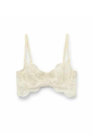 Lace bralette in off-white with scalloped edges and adjustable straps, featuring floral patterns and soft texture.