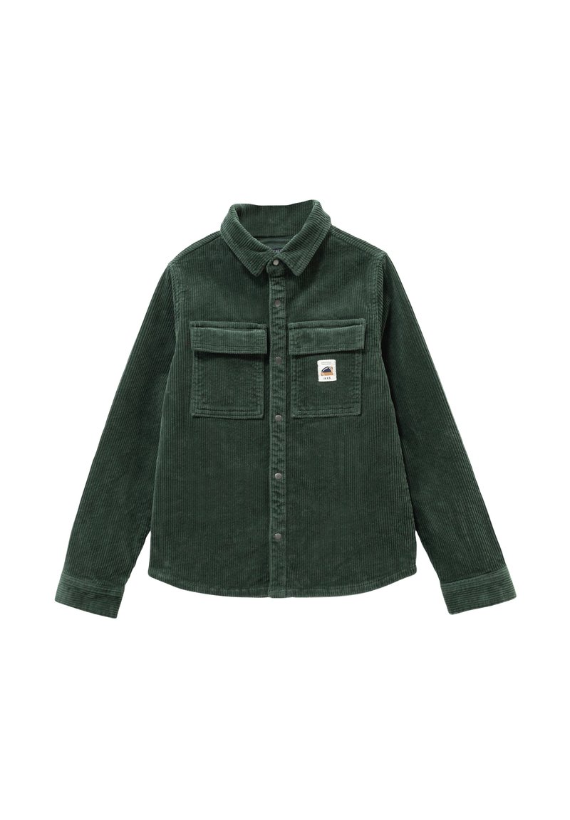 Camicia in velluto a coste verde scuro con colletto a punta, due tasche sul petto e un'etichetta sulla tasca sinistra. Presenta una chiusura frontale con bottoni.