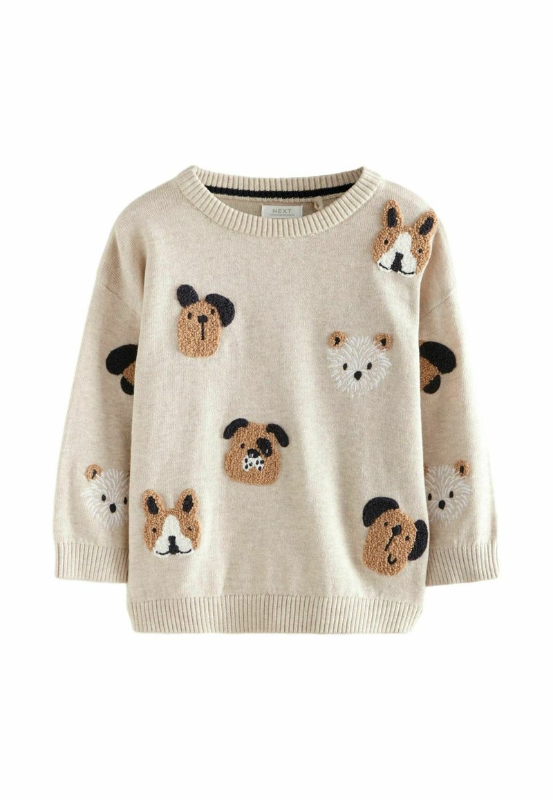 Pull en maille beige avec un col rond, présentant plusieurs appliqués de visages de chien en textures variées, de couleur marron, noir et blanc, répartis sur le tissu.