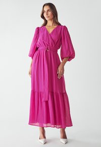 Langes pinkes Kleid aus plissiertem Stoff, mit V-Ausschnitt, Puffärmel, einem taillierten Bereich mit einer runden Schnalle und einem gestuften Rock.