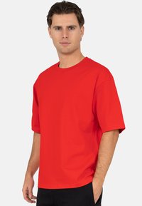 Rood katoenen T-shirt met korte mouwen, een ronde hals en een ontspannen pasvorm. Heeft een gladde textuur zonder zichtbare patronen of accenten.