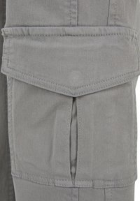 Pantaloni cargo gri, cu buzunar cu clapetă, material durabil, cusături structurate și o suprafață texturată. Ideali pentru utilizare practică.