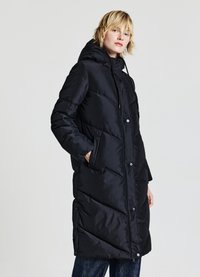 Manteau matelassé noir avec capuche, présentant un motif chevron, des boutons-pression et des poches latérales ; fabriqué en tissu brillant et lisse.