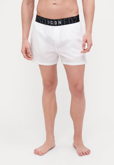 Weiße Boxershorts aus leichtem Material mit einem schwarzen elastischen Bund, der den Text "ICON" in fetten Buchstaben trägt.