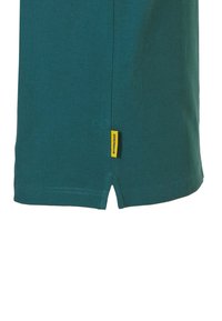 Teal katoenen t-shirt met een rechte snit, zijsplitten aan de zoom en een gele merklabel nabij de onderkant aan de linkerkant. Vlotte textuur en eenvoudig ontwerp.