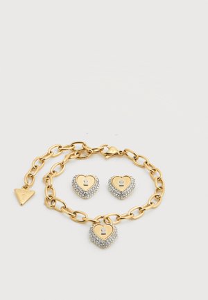 Βραχιόλι με αλυσίδα από χρυσαφί μέταλλο με μενταγιόν καρδιά σε σχέδιο κλειδαριάς, συνοδευόμενο από ταιριαστά σκουλαρίκια καρδιά με στρας.
