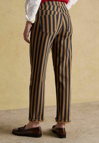 Pantaloni cu dungi verticale în albastru marin și maro, talie fitted și tivuri întoarse. Include două buzunare în partea din spate.