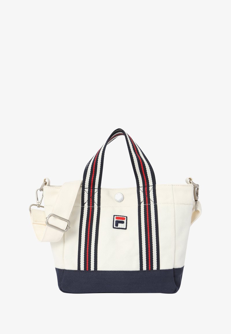 Petit sac fourre-tout blanc et marine avec des anses rayées rouges et noires et un patch logo à l'avant, doté d'une bandoulière amovible.