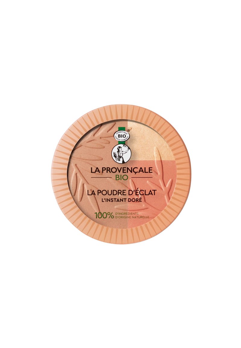 Poudre compacte dans un étui rond avec un schéma de couleurs corail clair et doré. Présente des textures de feuilles à la surface de la poudre. Étiquette écologique affichée.