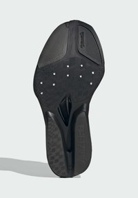 Black rubber shoe sole with textured surface, visible grooves, and perforations. Features Continental logo and "ADIZERO" branding.