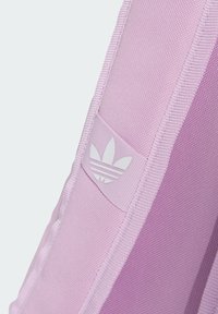 Borsa sportiva rosa con tessuto texturizzato, caratterizzata da un logo e strisce bianche. Il design include un gradiente di colore e dettagli di cucitura a contrasto.