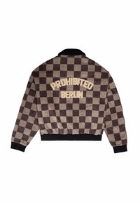 Veste à carreaux marron et beige avec col et poignets noirs, arborant le texte brodé "PROHIBITED BERLIN" dans le dos.