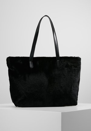 Zwarte nepbont schoudertas met gladde leren handvatten, rechthoekige vorm en zachte textuur. Eenvoudig ontwerp, geen zichtbare hardware of patronen.