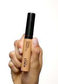 KIKO concealer in a creamy tan tube with a black cap. Includes text: "FULL COVERAGE DARK CIRCLES CONCEALER." Smooth texture.