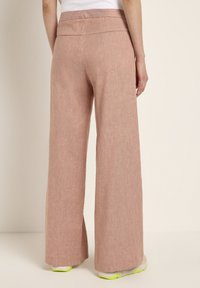 Wide-leg pants in light pink linen blend fabric. Features a smooth waistband and straight cut. Subtle texture with a relaxed fit.