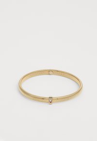 Bracelet flexible en ton doré avec fermoir intégré, présentant de petits détails rectangulaires rouges, blancs et noirs.