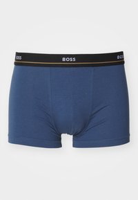 Kék boxer alsónemű, puha anyagból készült, fekete derékrészel, amelyen a "BOSS" logó fehér és arany díszítéssel található. Szabványos fit és dizájn.