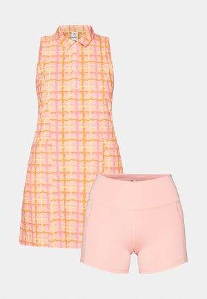 Polo štýlový top bez rukávov s geometrickým vzorom v ružovej, žltej a oranžovej farbe; spojený s priliehavými ružovými šortkami. Hladká tkanina, voľný dizajn.