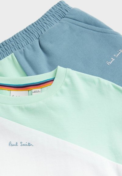 Svetlozelené a biele tričko s vyšívaním "Paul Smith", vrstvené pod modrými šortkami s elastickým pásom, s farebným pruhovaným vnútrom.