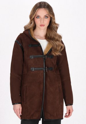 Cappotto in suede marrone con cappuccio e rivestimento in shearling beige, dotato di chiusure a pon-pon nere e accenti neri a contrasto. Texture liscia.