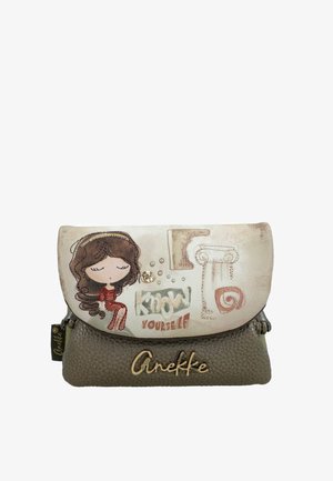 Pequeño bolso beige y marrón con una ilustración de una niña de dibujos animados, texto "Conócete a ti mismo", símbolos decorativos y el logotipo "Anekke" en la parte frontal.