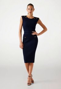 Abito blu navy a coste con silhouette aderente, design senza maniche, bottoni dorati decorativi sulle spalle e tasche, orlo al ginocchio.
