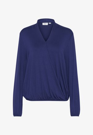 Tamsiai mėlynas, V formos, ilgomis rankovėmis marškinėliai, pagaminti iš minkštos medžiagos. Yra laisvas kirpimas su surinktu, elastingu apvadu, kuris suteikia formą.