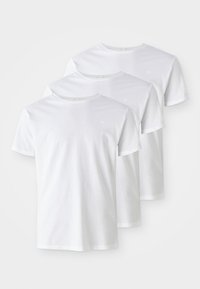 Trzy białe bawełniane t-shirty z okrągłym dekoltem, krótkimi rękawami i subtelnym logo na piersi. Gładka tekstura i standardowy krój.