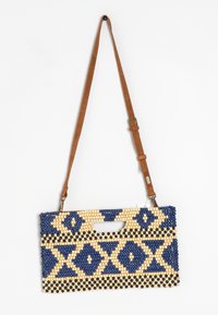 Bolso de mano con cuentas con un patrón geométrico en azul marino, crema y negro. Presenta una correa ajustable marrón y un asa en forma de corte.