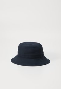 Marineblauwe bucket hat gemaakt van een zachte, gestructureerde stof. Heeft een brede rand en een ronde kroon met subtiele stikdetails.