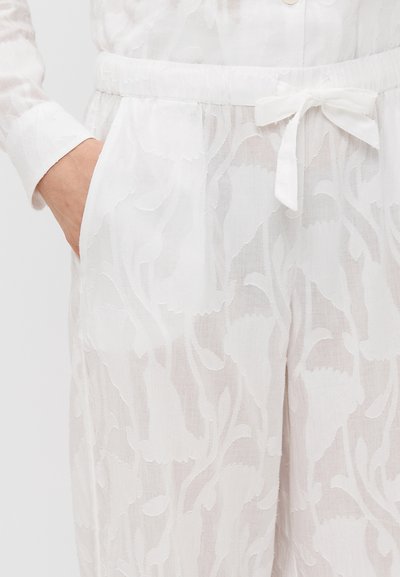 Biele ľanové oblečenie s jemným kvetinovým vzorom, elastický pás s šnúrkou na stiahnutie a bočné vrecká pre pohodlie.