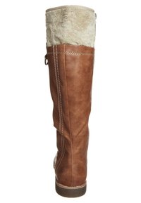Botte en cuir brun haute avec un haut en fourrure crème douce. Présente des coutures blanches contrastantes et une semelle texturée pour l'adhérence.