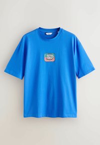 T-shirt bleu vif à manches courtes avec un col rond et un petit graphisme coloré de boîte de sardines centré sur la poitrine.