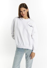 Witte sweatshirt met een ronde hals, geribde manchetten en zoom, met kleurrijke geborduurde wolk en tekstdetails aan de linkerkant.