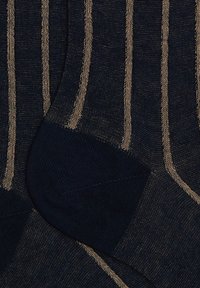Calzini navy con strisce verticali dorate, realizzati in tessuto morbido. Caratteristiche notevoli includono talloni e punte rinforzati, texture liscia.