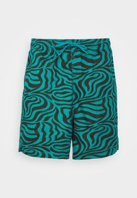 Un maillot de bain à motif turquoise et noir avec un design en vague, une taille élastique avec cordon de serrage et des ourlets cousus.