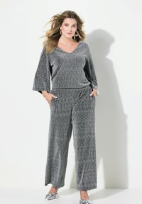 Grijze two-piece outfit bestaande uit een losse V-hals top met driekwart mouwen en brede broekspijpen, gemaakt van textuurstof met verticale strepen.