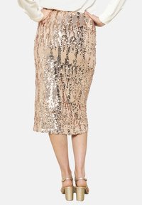 Aukšto juosmens pieštuko sijonas su blizgučiais aukso ir sidabro atspalviuose, turintis prigludusią siluetą ir siūlę, baigiančiąsi po keliu.