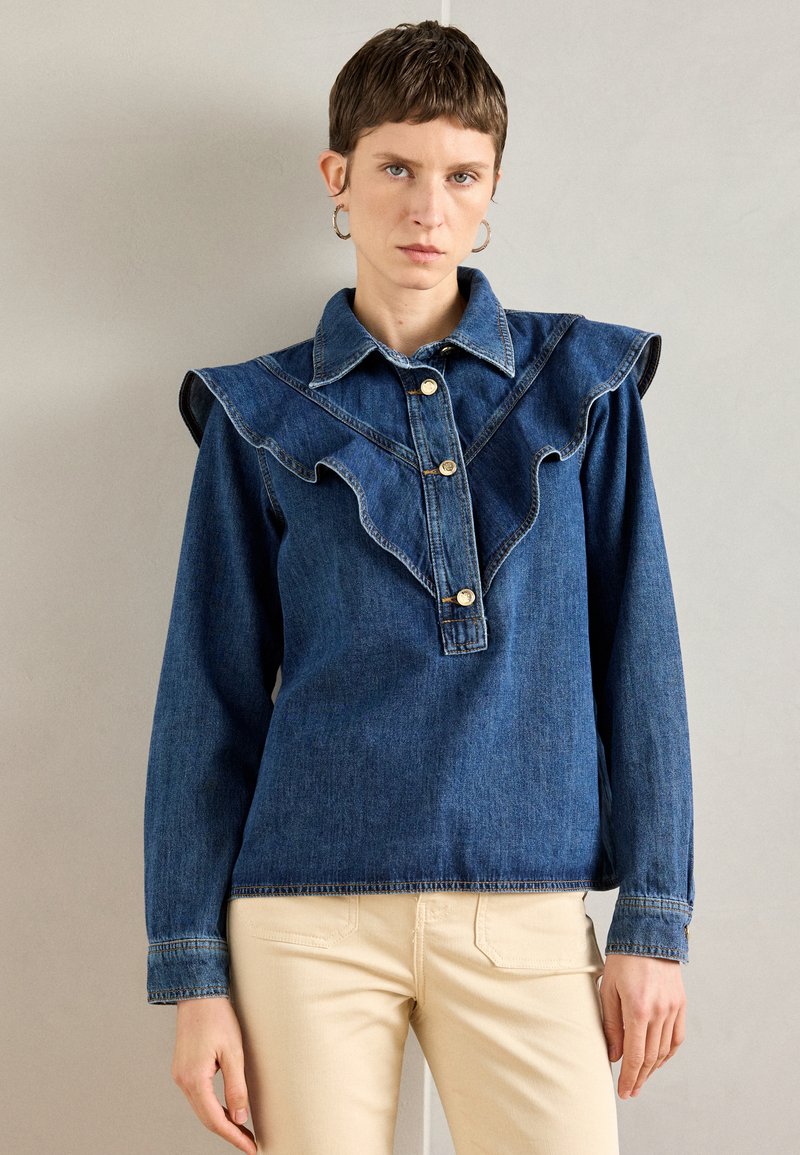 Τζην πουκάμισο με φρουφρού κολάρο και γιακά, με χρυσά κουμπιά και μακριά μανίκια. Μπλε ύφασμα με λεία υφή.