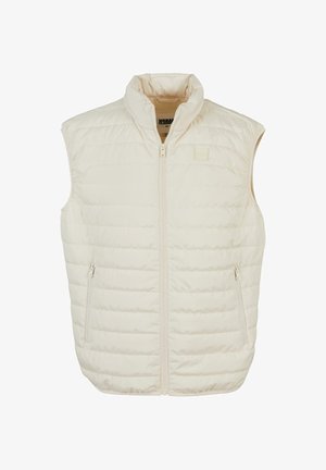 Let beige dunvest med høj krave, frontlynlås og to sidelommer med lynlås; har vandrette syninger for struktur.