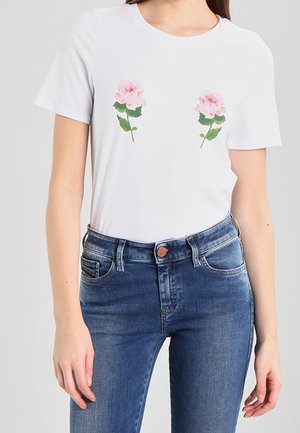 T-shirt blanc à manches courtes avec deux impressions de roses roses. Associé à un jean denim bleu à coupe classique et à cinq poches.