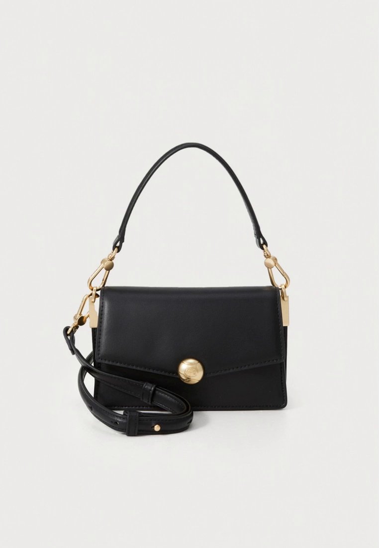 Sac à main en cuir noir avec une poignée incurvée et une bandoulière amovible. Doté d'une fermeture magnétique, de ferrures dorées et d'une texture lisse.