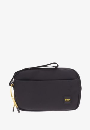 Funda negra con cremallera, hecha de un tejido suave, que incluye una correa para la muñeca, un bolsillo frontal y detalles amarillos en los tiradores de la cremallera.